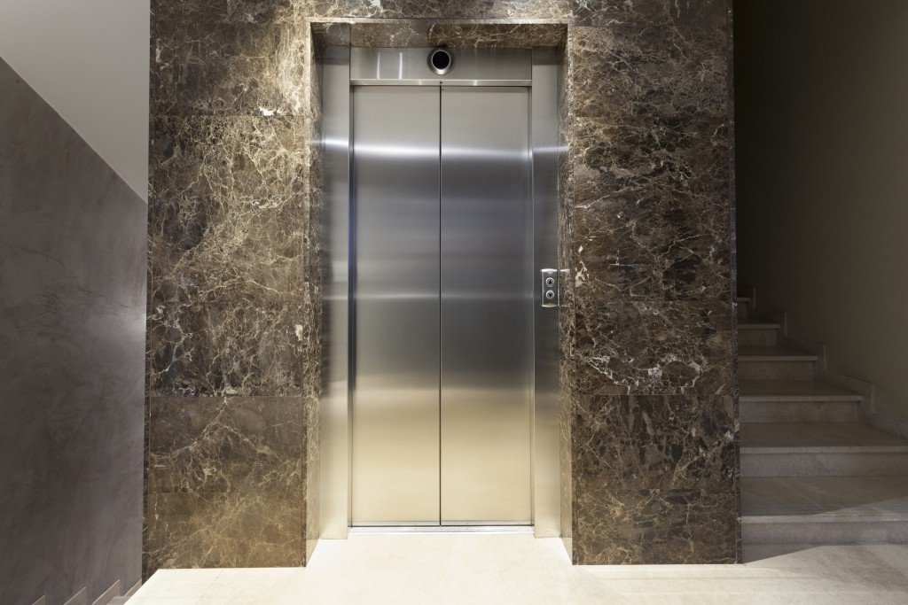 Interior of a corridor with passenger lift and marble stairs